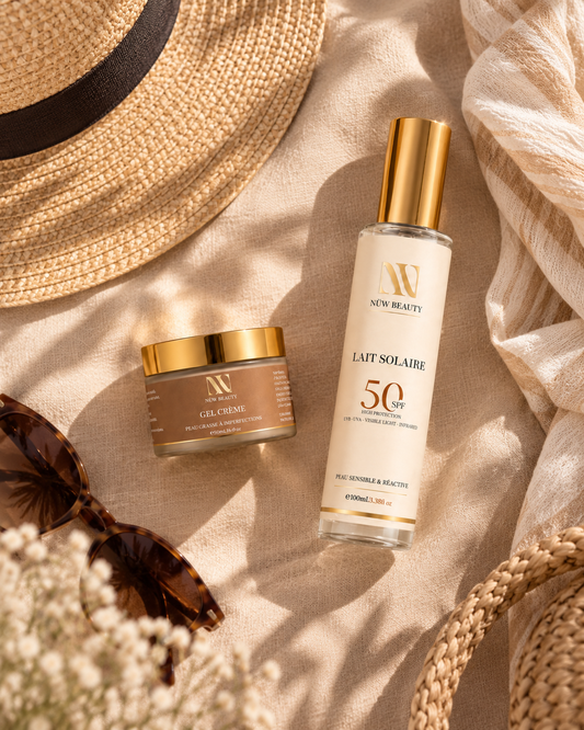 Duo Protection NÜW BEAUTY posé sur un tissu beige avec accessoires d’été