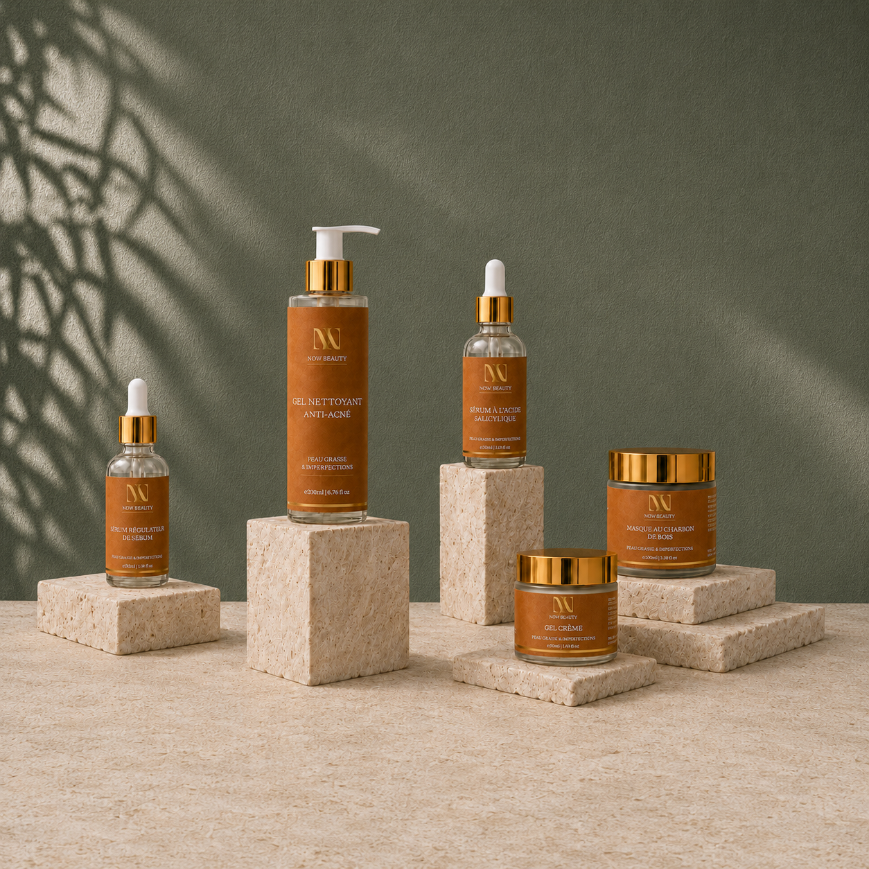 Les cinq produits NÜW BEAUTY présentés sur des socles avec ombres de feuillage